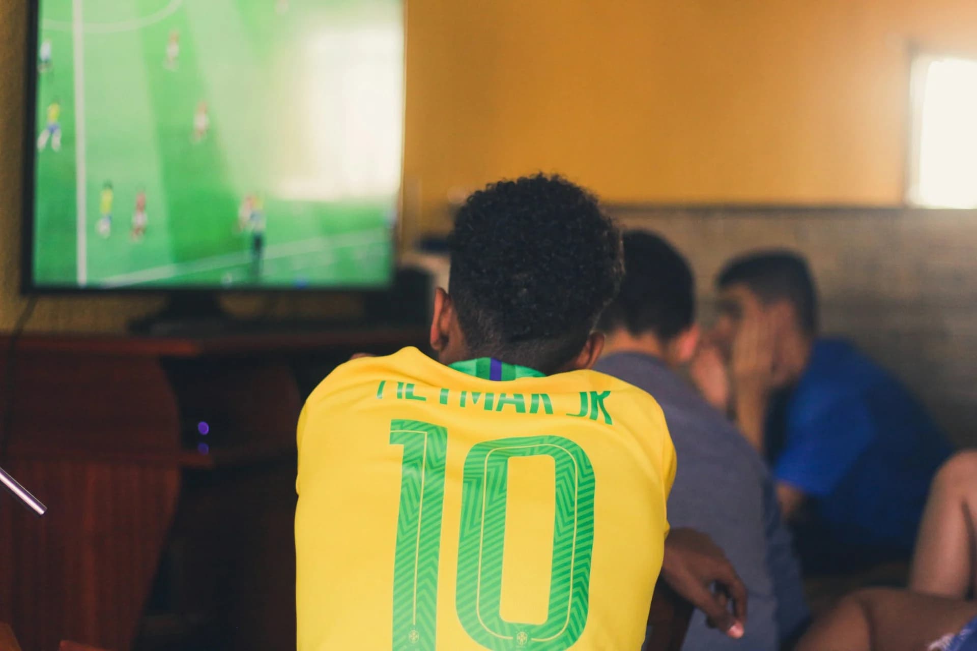 Football supporter watching a live match on television